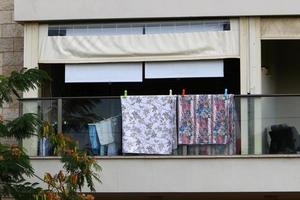 Washed clothes and linen dries on the balcony. photo