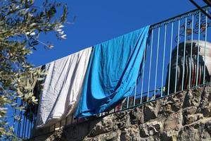 Washed clothes and linen dries on the balcony. photo