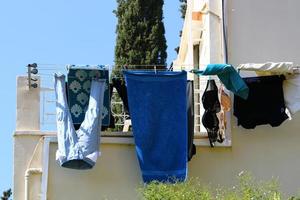 Washed clothes and linen dries on the balcony. photo