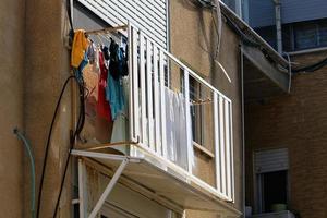 Washed clothes and linen dries on the balcony. photo