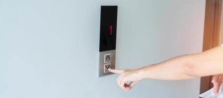 Hand finger press the Elevator button, woman waiting for Elevator in office or apartment photo