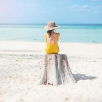 Woman tourist in yellow swimsuit and hat, solo traveller looking beautiful sea view at bamboo island on Phi Phi don island, Krabi, Thailand. destination, summer Travel, vacation and holiday concept photo