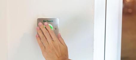 abra la puerta a mano sin el interruptor del sensor táctil en la pared de la oficina o apartamento. concepto sin contacto, moderno, tecnológico y de seguridad foto