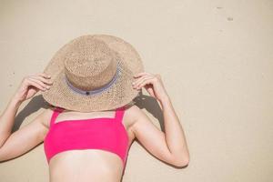 Woman tourist in pink swimsuit and hat, happy traveler sunbathing at Paradise beach on Islands. destination, wanderlust, Asia Travel, tropical summer, vacation and holiday concept photo