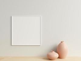 Clean and minimalist front view square white photo or poster frame mockup hanging on the wall with vase. 3d rendering.