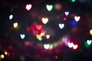 luces multicolores en forma de corazones. fondo borroso bokeh foto