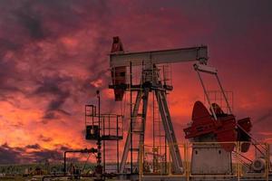 Oil drill rig and pump jack at sunset background. photo