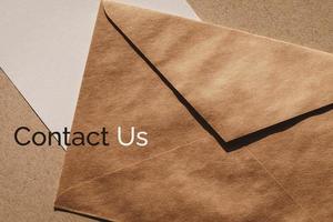 Contact us banner for customer support web page, brown envelope and white paper note photo