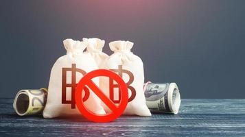 Thai baht money bags and red prohibition symbol No. Sanctions. Economy crisis. Urgent stock market close. Freezing assets, banning transactions. Devaluation. Capital export outflow restrictions. photo