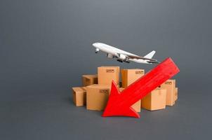 Airplane over boxes and red down arrow. Decline of goods transportation volume, world trade traffic delays. Delivery by air. High demand and low proposition for express delivery. Cargo aircraft photo