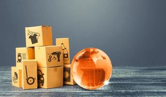 Orange glass earth globe and boxes. International world trade distribution. Delivery of goods, shipping. Globalization markets. Economics development. Global economy, import export freight traffic. photo