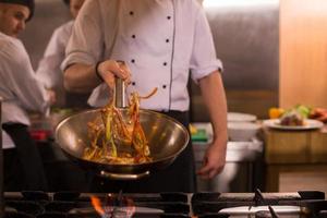 chef flipping vegetables in wok photo