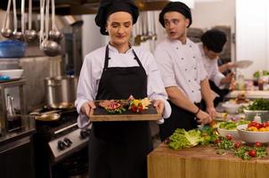 female Chef holding beef steak plate photo