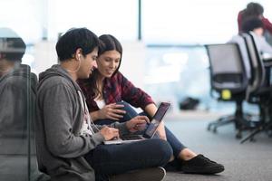 pareja de desarrolladores de software trabajando en el piso foto