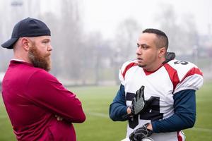 american football player discussing strategy with coach photo