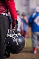 American football player holding helmet photo