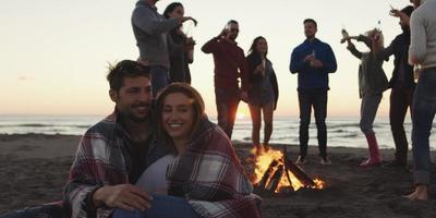 Friends having fun at beach on autumn day photo