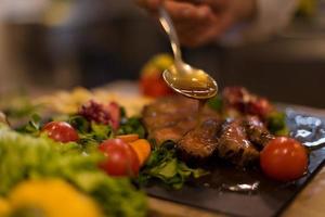 Chef finishing steak meat plate photo