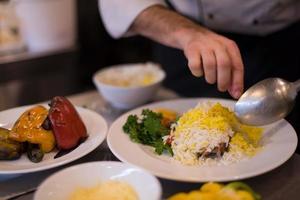 Chef hands serving vegetable risotto photo