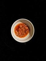 Chili sauce in a white container photo