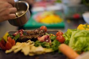 Chef finishing steak meat plate photo