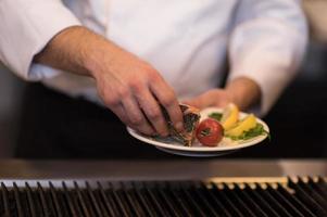 chef manos cocinando salmón a la parrilla foto