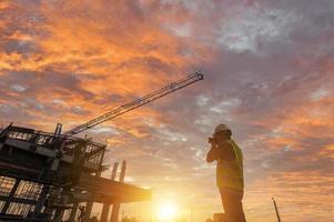 Engineer on a construction site passing by a construction site that blurs at sunset, an engineer inspects the construction of a water catchment tower photo