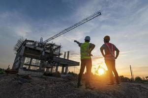 Engineer on a construction site passing by a construction site that blurs at sunset, an engineer inspects the construction of a water catchment tower photo