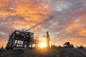 Engineer on a construction site passing by a construction site that blurs at sunset, an engineer inspects the construction of a water catchment tower photo