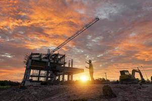 Engineer on a construction site passing by a construction site that blurs at sunset, an engineer inspects the construction of a water catchment tower photo