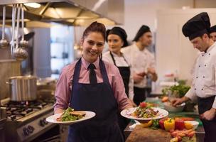 young waitress showing dishes of tasty meals photo