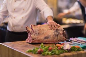 chef cutting big piece of beef photo