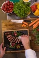top view of Chef finishing steak meat plate photo