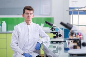 estudiante científico mirando a través de un microscopio foto