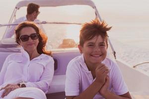 A senior couple in casual outfits with their son enjoy while riding a boat at sea at sunset. The concept of a happy family. Selective focus photo