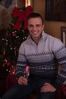 Happy young man with a glass of champagne photo