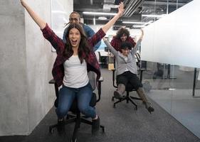 multiethnics business team racing on office chairs photo