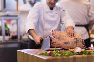 chef cortando un gran trozo de carne foto