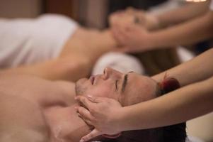 couple enjoying head massage at the spa photo