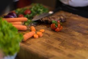 Juicy slices of grilled steak on wooden board photo