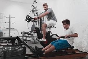 padre e hijo entrenan juntos en el gimnasio de casa. el concepto de vida sana. enfoque selectivo foto