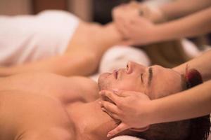 pareja disfrutando de un masaje de cabeza en el spa foto