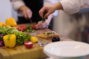 Chef hands preparing marinated Salmon fish photo