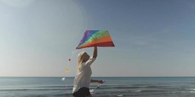 Young Woman holding kite at beach on autumn day photo