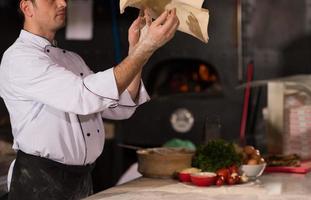 chef throwing up pizza dough photo