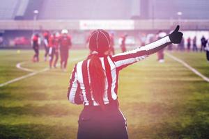 rear view of female american football referee photo