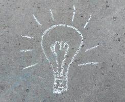 the light bulb is drawn with chalk on the pavement. creative idea concept. photo