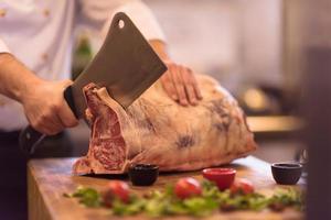 chef cutting big piece of beef photo