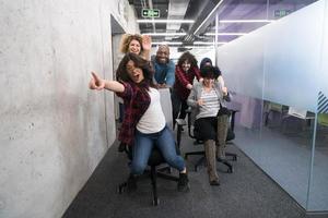 multiethnics business team racing on office chairs photo