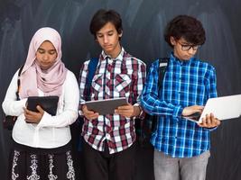 los adolescentes árabes modernos usan teléfonos inteligentes, tabletas y latpop para estudiar durante las clases en línea debido a la pandemia del virus de la corona foto